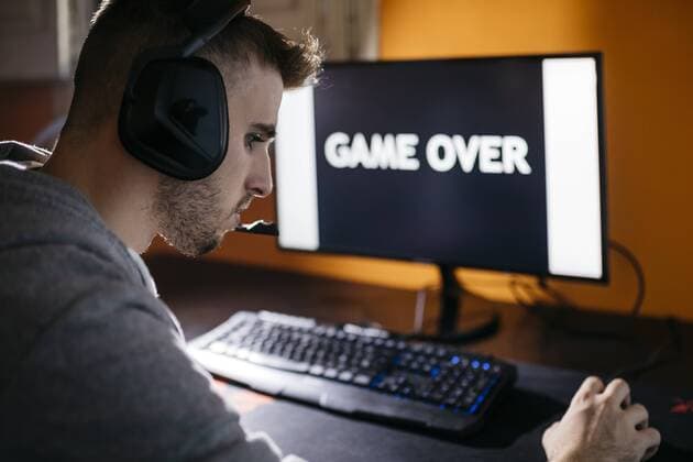 Young man sitting at his PC, looking at screen with game over text model released Symbolfoto  JRFF02022