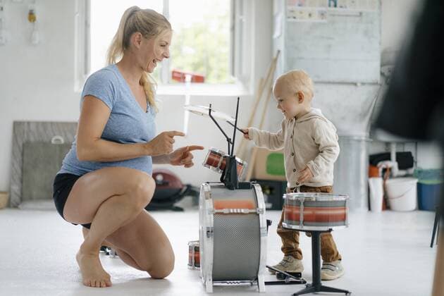 Happy pregnant mother with toddler son playing toy drums model released Symbolfoto property released  KNSF05197