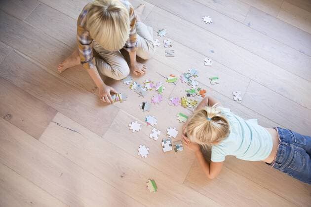 Brother and sister lying on the floor at home playing jigsaw puzzle model released Symbolfoto property released  MFRF01120