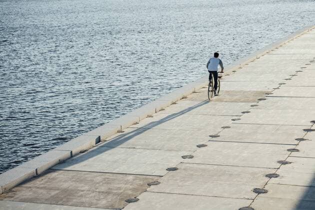 Young man riding bike on waterfront promenade at the riverside model released Symbolfoto  VPIF01035