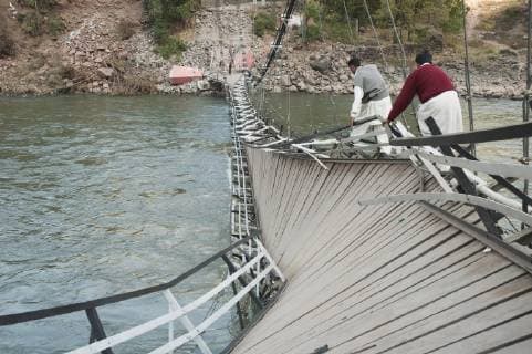 Men Walking On A Collapsed Suspension Bridge Over The Jelhum River After The 8 October 2005 Earthquake, Garhi Dopatta, Azad Jammu & Kashmir, Pakistan  Copyright: PeterxLanger 2088041