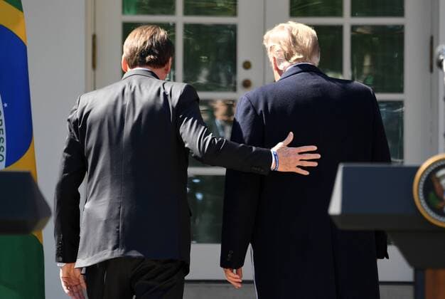Brazilian President Jair Bolsonaro puts his hand on the back of President Donald Trump after a joint press conference with in the Rose Garden at the White House in Washington, DC on March 19, 2019.  WAP201903199031 PATxBENIC