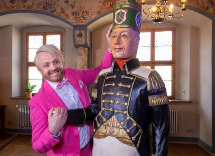 Shooting for the MDR show Musik für Sie in the Rathaus in Annaberg Buchholz on 20 03 2019 Singer and entertainer Ross Antony stands next to a carved miners figure in historical costume Annaberg Buchholz Sachsen Germany