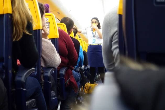 27.01.2019, Schoenefeld, Brandenburg, GER - Flugbegleiterin der Ryanair bei der Sicherheitseinweisung vor dem Abflug. (Airline, Alltag, Atemmaske, Billigflieger, Billigfluggesellschaft, Bordeinweisung, Brandenburg, deutsch, Deutschland, Dienstleistung, Economy, eng, Enge, Europa, europaeisch, Ferien, Ferienflieger, Fernreise, fliegen, Flieger, Flug, Flugbegleiterin, Flugbetrieb, Fluggaeste, Fluggesellschaft, Fluglinie, Flugpassagiere, Flugreise, Flugverkehr, Flugzeug, Flugzeugkabine, Frau, Gang, Gesellschaft, innen, Innenaufnahme, Innenraum, irisch, Kaukasier, kaukasisch, Linienflug, Luftfahrt, Luftfahrtgesellschaft, Luftfahrtunternehmen, Luftverkehr, Maschine, Menschen, Passagiere, Passagierflugzeug, Passagiermaschine, QF, Querformat, Reise, Reiseform, Ryanair, Schoenefeld, Service, Servicepersonal, Sicherheitsdemonstration, Sicherheitse