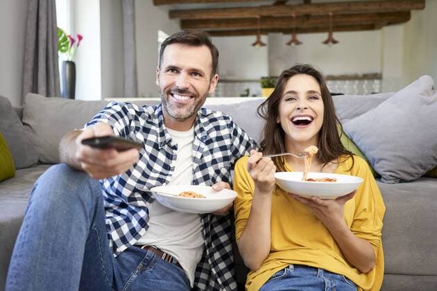 Couple sitting in living room, eating spaghetti, watching TV model released Symbolfoto property released  BSZF00872
