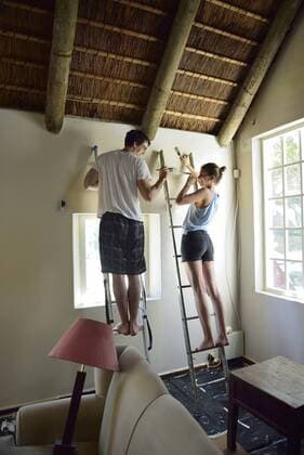 Young couple renovating their home painting the wall together model released Symbolfoto property released  ECPF00188
