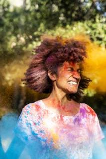 Woman shaking her head, full of colorful powder paint, celebrating Holi, Festival of Colors model released Symbolfoto  ERRF00470