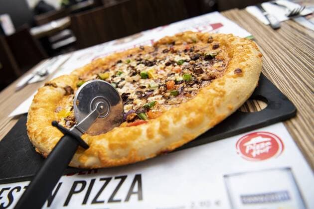 Pizza Chicken Supreme marinated grilled chicken meat with beef peperoni sausage vegetables mix and Kaeserand pizza supplier restaurant Pizza Hut delivery service logo Munich