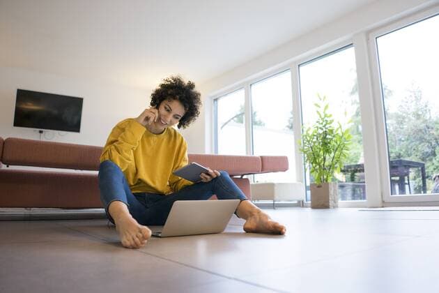 Smiling woman using laptop and tablet at home model released Symbolfoto property released  JOSF02768
