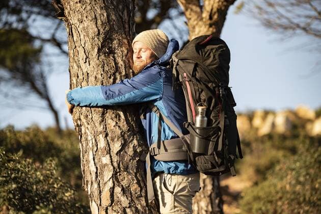 Man on a hiking trip hugging a tree model released Symbolfoto  KBF00431