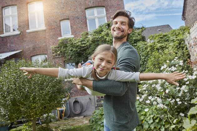 Happy father playing with daughter in garden of their home model released Symbolfoto property released  RORF01603
