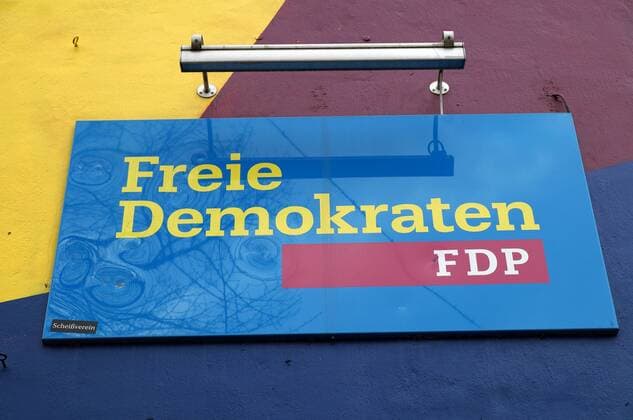 The party logo of the Free Democrats at the Bremen FDP House The party building is painted in the party colours An opponent of the party has provided the sign with a sticker Fuck club