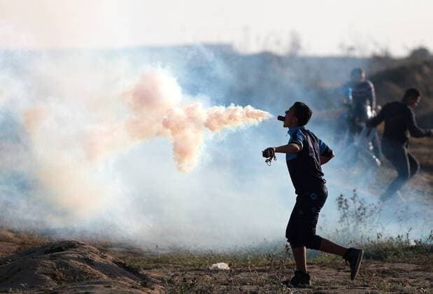 News Themen der Woche KW15 (190412) -- GAZA, April 12, 2019 -- A Palestinian protester holds a tear gas canister fired by Israeli troops in his mouth during clashes on the Gaza-Israel border, east of al-Bureij refugee camp in central Gaza, on April 12, 2019. The Israeli army shot dead a Palestinian boy on Friday and wounded dozens during clashes with hundreds of Palestinian demonstrators in eastern Gaza Strip, close to the border with Israeli, according to medics. ) MIDEAST-GAZA-CLASHES YasserxQudih 