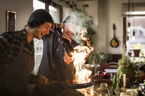 Friends flambeing food in a pan, producing a big flame model released Symbolfoto property released  MJRF00059
