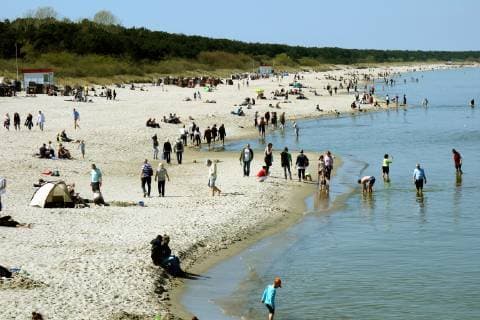 Holidaymakers and locals are attracted by the beautiful weather on the Baltic Sea at Easter With water temperature of 7° degrees and air temperature of 16° degrees some bathers are already in the water 21 04 2019 Mecklenburg-Western Pomerania