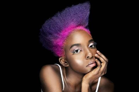 Portrait of eccentric young woman with pink and purple dyed hair in front of black background model released Symbolfoto  DMOF00138