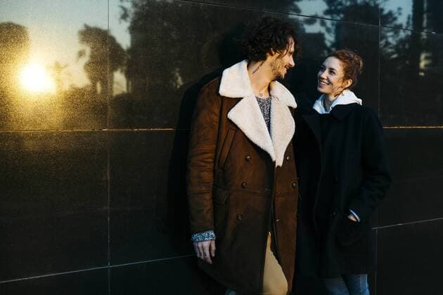 Couple at a black wall with reflections talking to each other model released Symbolfoto  JRFF02716