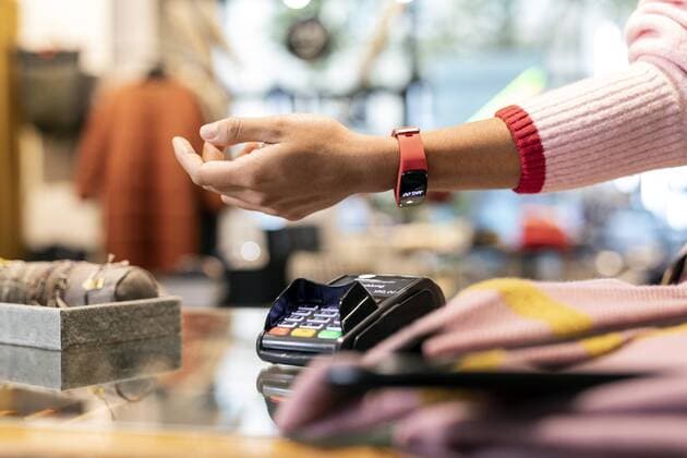 Customer paying contactless with her smartwatch model released Symbolfoto property released  PESF01539