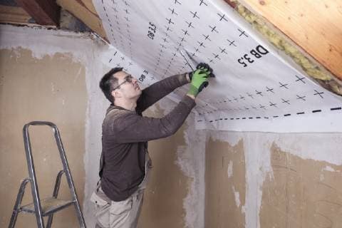 Roof insulation, worker fixing sarking membrane model released Symbolfoto property released  SEBF00038