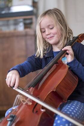 Portrait of smiling blond girl playing cello model released Symbolfoto  HAMF00560