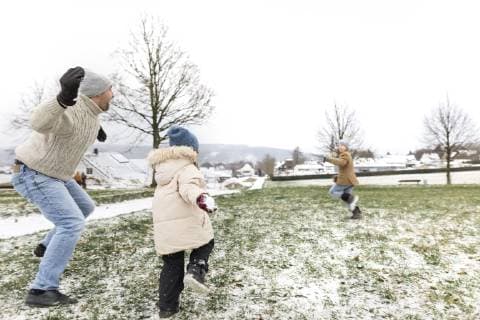 Father and two children having a snowball fight model released Symbolfoto  KMKF00681