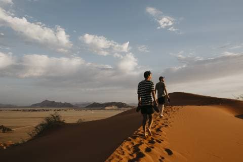 IMAGO Creative: Sommer, Abendspaziergang Namibia, Namib desert, Namib-Naukluft National Park, Sossusvlei, two men walking on Elim Dune at sunset model released Symbolfoto  LHPF00254