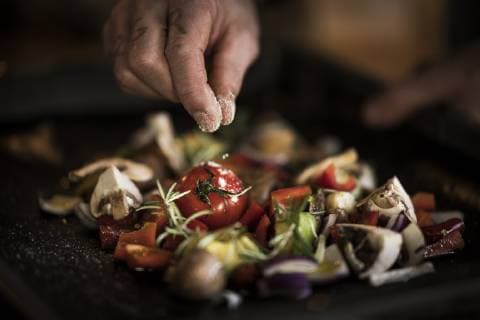 Hand seasoning vegetables ona a baking tray model released Symbolfoto property released  MJRF00062