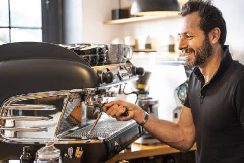 Smiling barista preparing coffee in a coffee shop model released Symbolfoto  OCMF00268