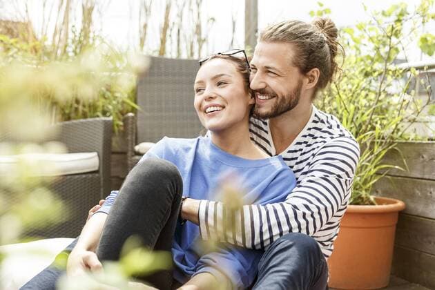 Young couple relaxing on their balcony, embracing model released Symbolfoto property released  PESF01176