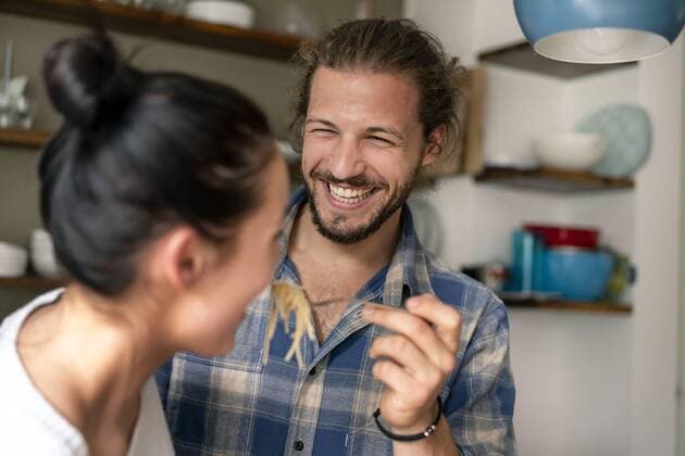 Young couple preparing food together, tasting spaghetti model released Symbolfoto property released  PESF01242