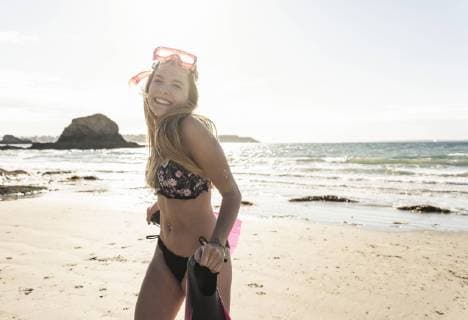 Happy young woman with snorkelling equipment, running on the beach model released Symbolfoto  UUF16500