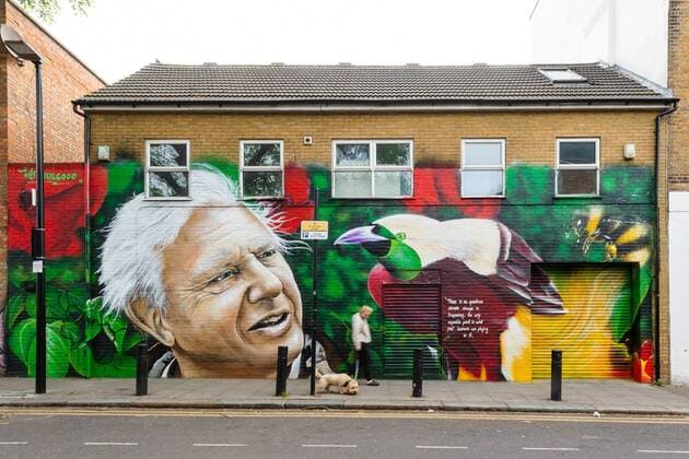 IMAGO ICONS: Sir David Attenborough May 6, 2019 - London, London, UK - London, UK. A woman and her dog walk past a new David Attenborough Mural painted on the side of a house in St Matthew s Row, east London. The mural by urban artist, Jerome shows natural historian, David Attenborough with a message, There is no question climate change is happening. The only arguable point is what part humans are playing in it London UK  - ZUMAl94_ 20190506_zaf_l94_006 Copyright: xVickiexFloresx