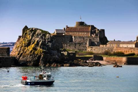 Saint Helier, Jersey April 29, 2019 - Image of Elizabeth Castle famous tourist attraction in the Island of Jersey ILLUSTRATION, ILLUSTRATIF, GENERIQUE, SAINT HELIER, JERSEY, HISTOIRE, PATRIMOINE, CHATEAU ELIZABETH, ROYAUME UNI, UK, ILES ANGLO NORMANDES, TOURISME, SITE TOURISTIQUE, VOYAGE, INSULAIRE, ILE DE JERSEY, BAILLIAGE DE JERSEY, SITE HISTORIQUE, MONUMENT, DEFENSE, FORTERESSE, COURONNE BRITANNIQUE, CARTE POSTALE, ROCHER, PAYSAGE  Copyright: xVincentxIsorex