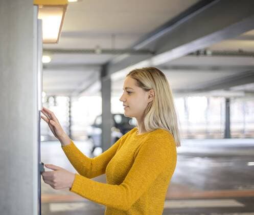 young woman at the parking ticket machine