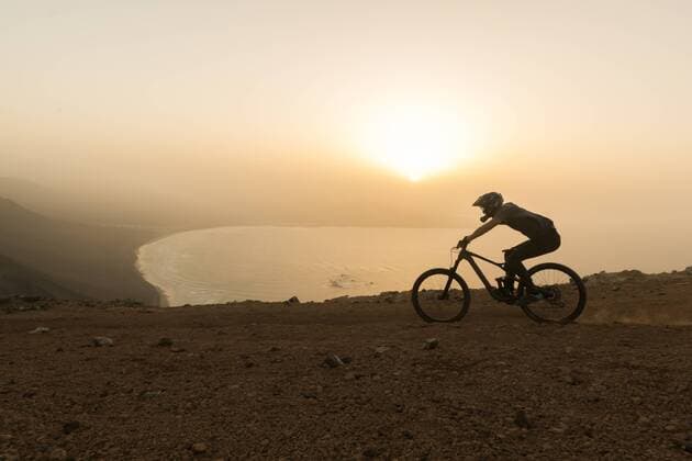 Spain, Lanzarote, mountainbiker on a trip at the coast at sunset model released Symbolfoto  AHSF00112