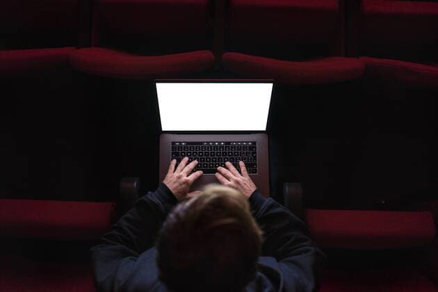 Director sitting at auditorium of theatre working on laptop, top view model released Symbolfoto property released  FBAF00282