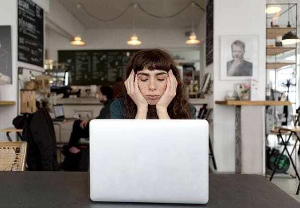 Frustrated young woman using laptop in a cafe model released Symbolfoto property released  FLLF00066