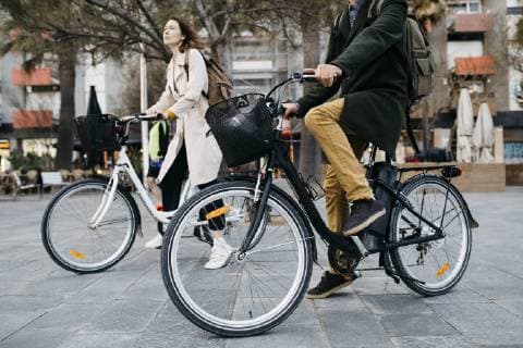 Couple riding e-bikes in the city model released Symbolfoto  JRFF02983