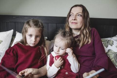 Mother and two girls relaxing with book in bed model released Symbolfoto property released  KMKF00850