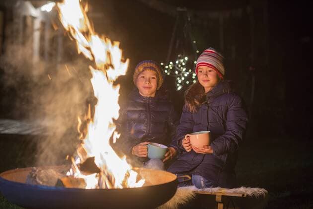 Boy and girl with mugs sitting at the fire at night model released Symbolfoto  LBF02497
