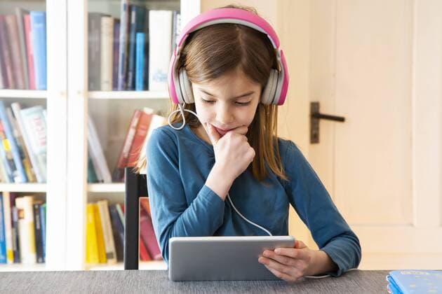 Little girl doing homework with headphones and digital tablet model released Symbolfoto property released  LVF07945