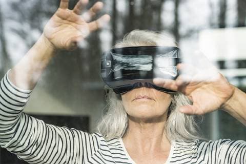 IMAGO Creative: Digitale Welt, Mixed Reality Portrait of mature woman behind windowpane using Virtual Reality Glasses model released Symbolfoto property released  SBOF01882