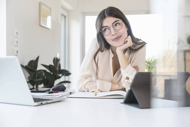 Portrait of smiling young woman sitting at table at home model released Symbolfoto property released  UUF16966