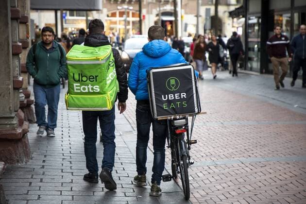 Amsterdam, Netherlands, Couriers of food online delivery service via Eats, bicycle supplier and delivery courier on foot,