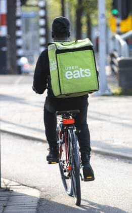 Amsterdam, Netherlands, Couriers of food online delivery service via Eats, bicycle supplier and delivery courier on foot,