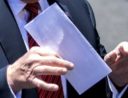 President Donald Trump holds up a letter that he says is the secret agreement with Mexico that put on hold the increase in tariffs, during an impromptu press conference on the South Lawn of the White House in Washington, DC on June 11, 2019. He then departed for Iowa.  WAS2019061113 PATxBENIC