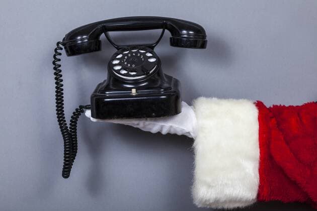 Santa Claus holds black old phone