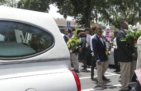 June 22, 2019 - Temple Terrace, Florida, U.S. - Members of Tampa s Men of Vision group carry bouquets of flowers past by the hearse that will carry 14 year old Hezekiah B. Walters to his final resting place on Saturday, June 22, 2019 in Temple Terrace. Walters, a Middleton High football player, collapsed and subsequently died after running conditioning drills at the school. Temple Terrace U.S. - ZUMAs70_ 20190622_zan_s70_003 Copyright: xAngeliquexHerringx