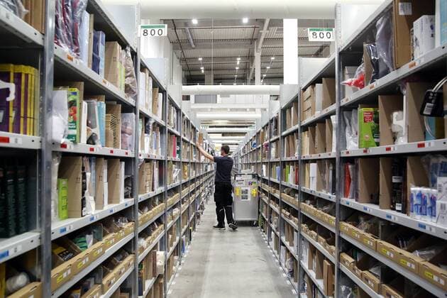 26 11 2018, Brandenburg Brieselang Amazon Photo an employee sorts goods on the shelves From there they wait for sale