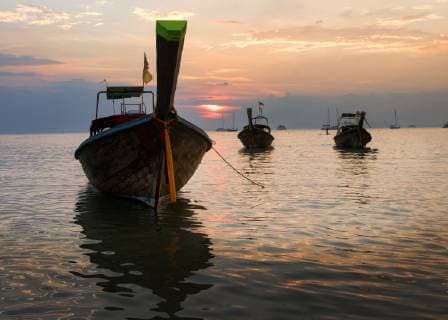Thailand, Krabi, Railay beach, long-tail boats floating on water at sunset  ALRF01177